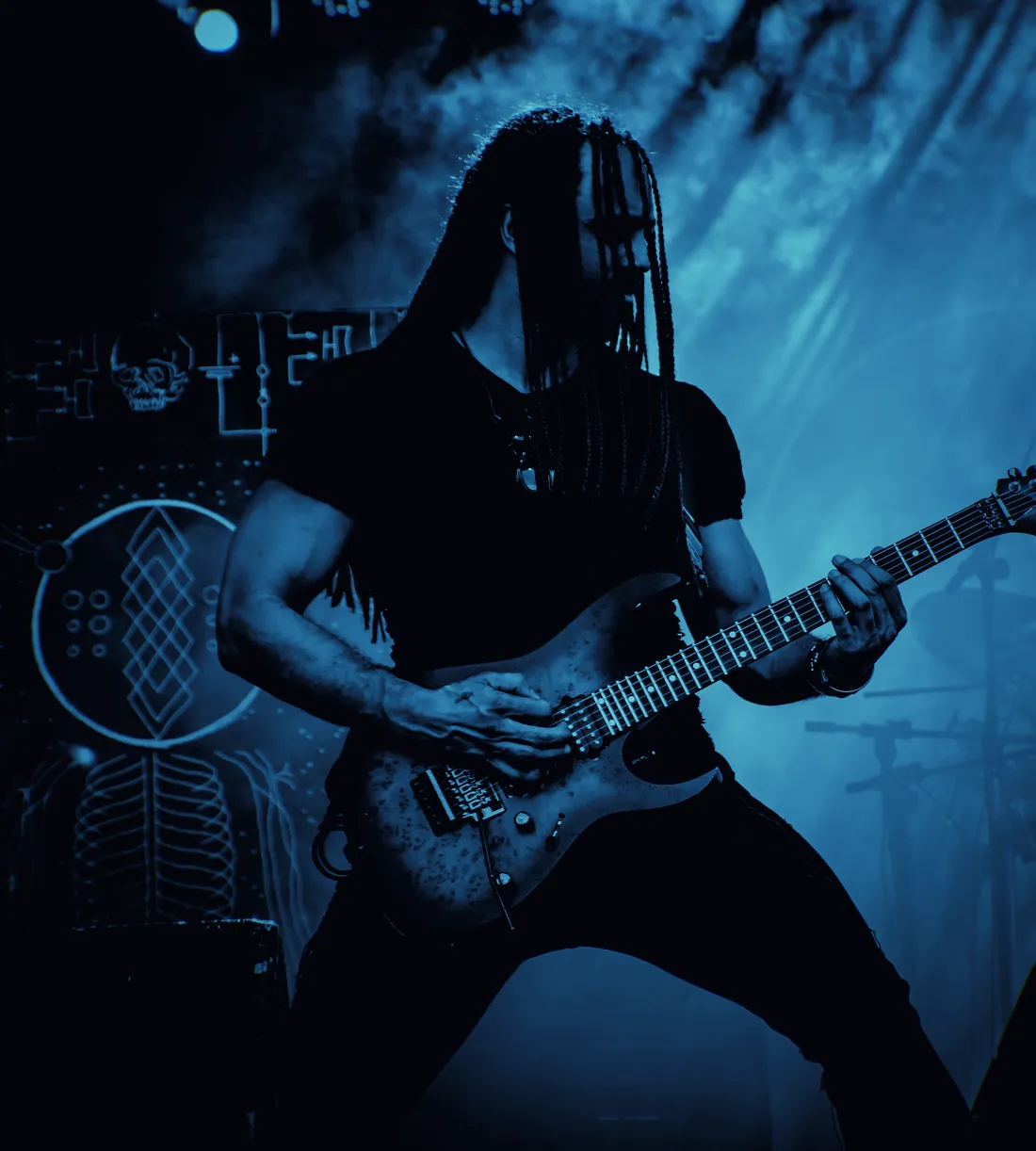 Marcelo Barbosa tocando guitarra no palco, no meio da fumaça